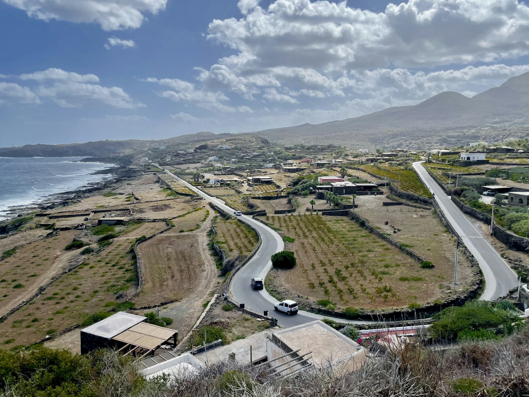 An aerial view of Pantelleria's volcanic coast and winding road