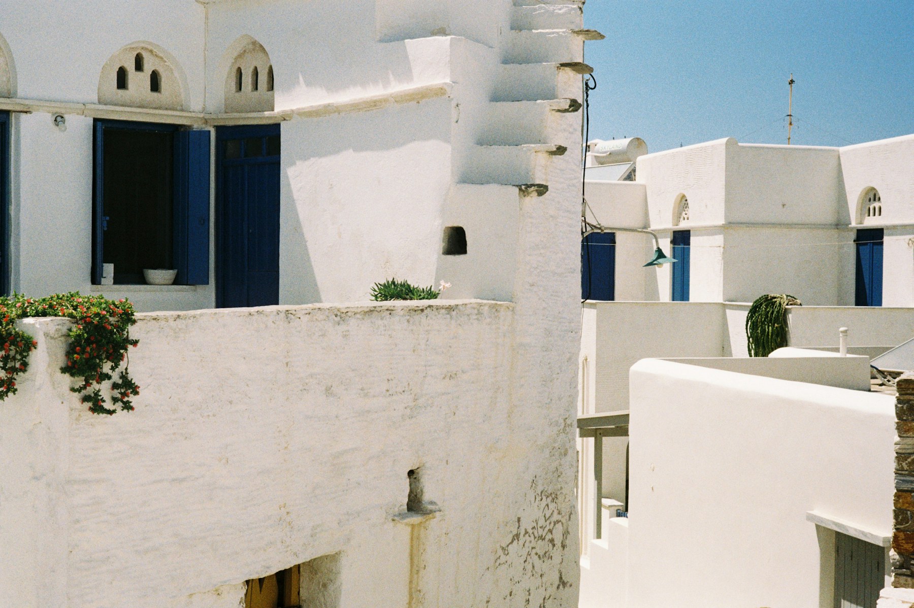 Whitewashed Tinos buildings with blue shutters